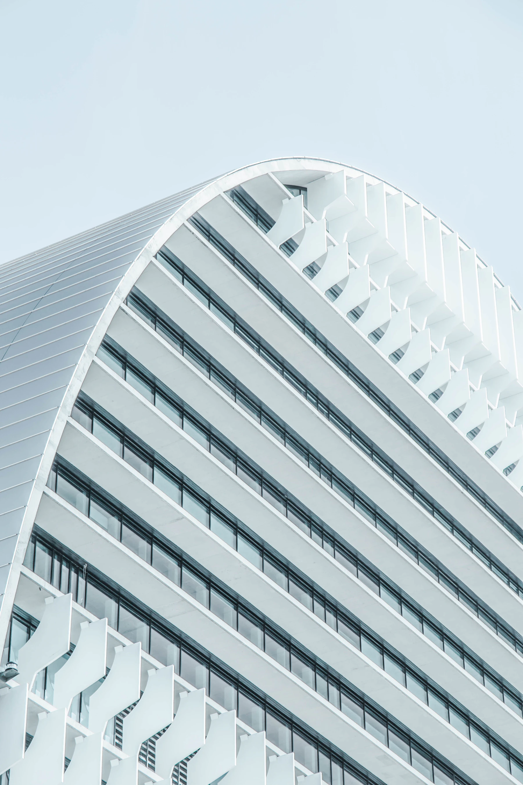 The curved white façade of a building in Madrid, photographed from below by Joel Filipe.