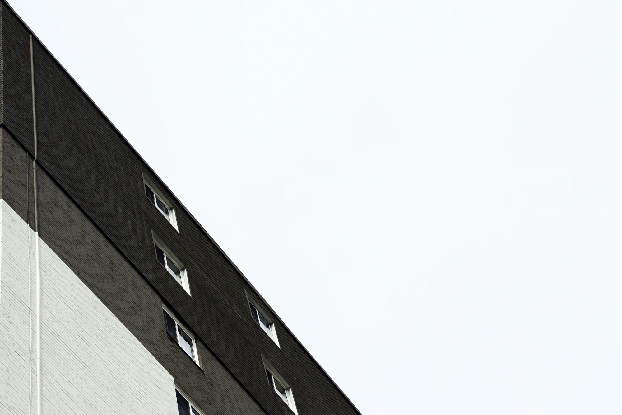 A sharply angled façade meeting a wide, quiet expanse of sky.